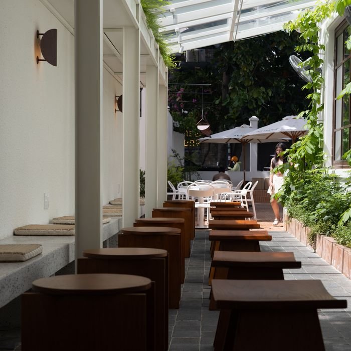 Minimalist outdoor café with modern seating and natural lighting, perfect for a relaxing day.